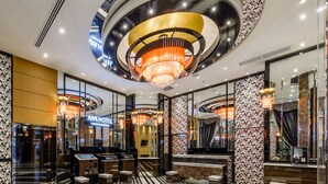 A modern hotel lobby with a central chandelier, reflective black and white patterned walls, and a reception desk. - APA Hotel Hakata Gion Ekimae (Fukuoka)