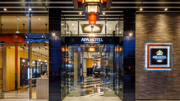The exterior of APA Hotel with a modern design, featuring a prominent entrance, glass doors, and a sign displaying the hotel's name. - APA Hotel Hakata Gion Ekimae (Fukuoka)