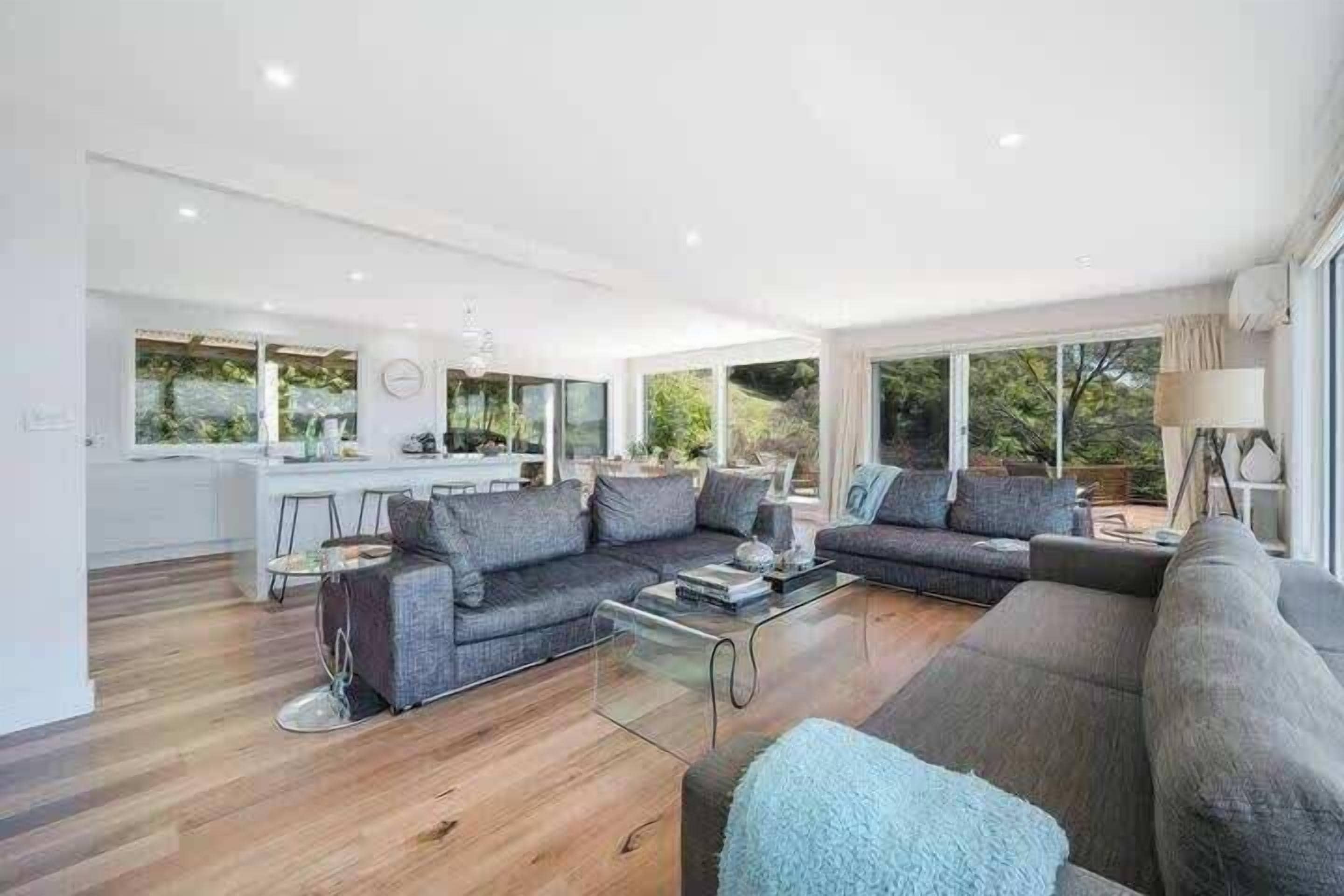 A modern living room with a sofa set, a coffee table, and a lamp.