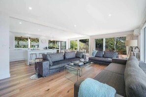 A modern living room with a sofa set, a coffee table, and a lamp.