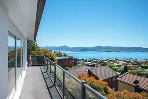 A balcony with a view of a lake and distant mountains. - House on the Hill with a View – Sleeps 12, 3 Bath. (Sandy Bay)
