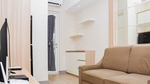 Un salon moderne avec un canapé beige, une table en bois sur laquelle sont posés des appareils électroniques, et un design minimaliste.