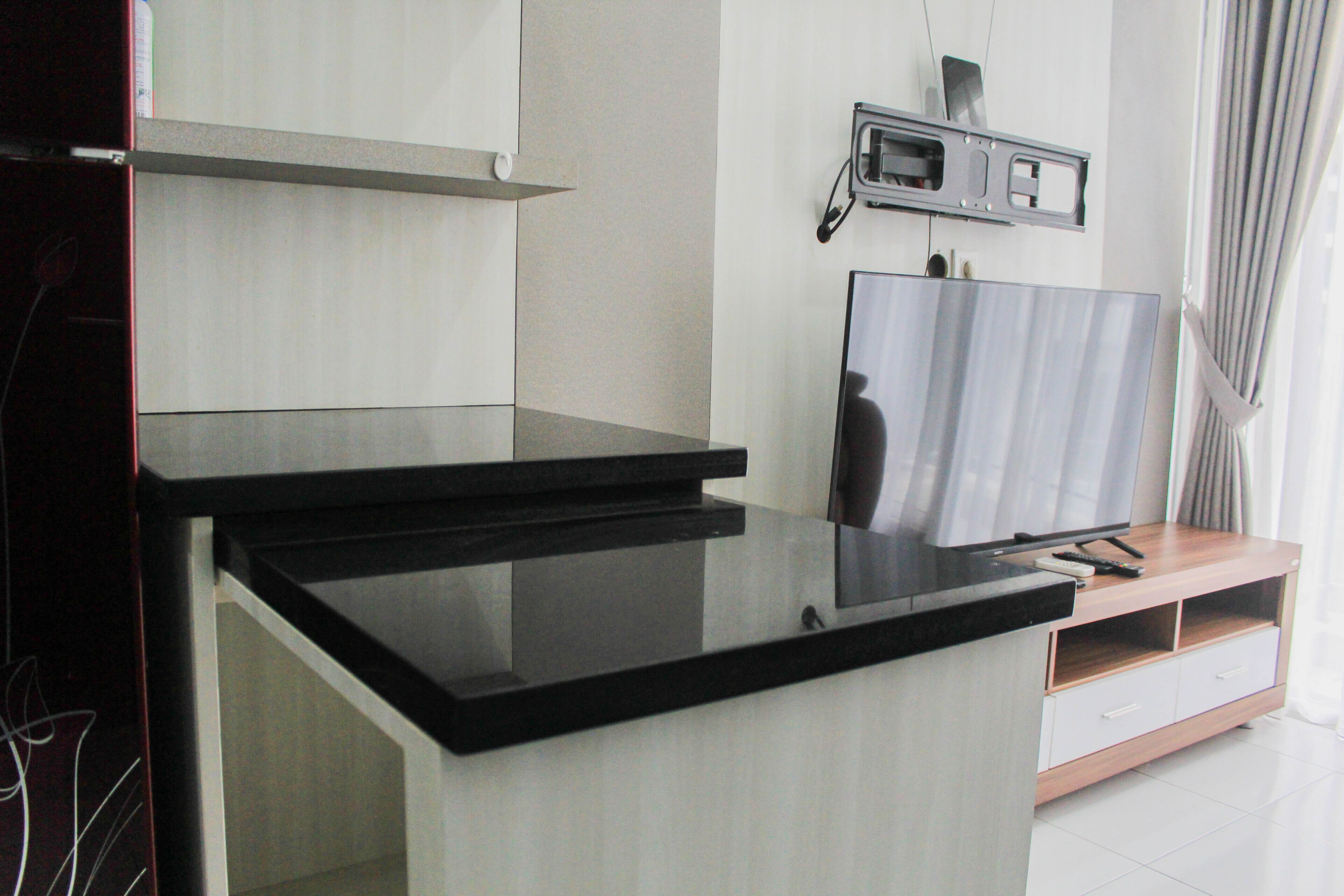 A modern kitchen with a black countertop, a built-in oven, and a microwave.