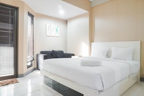 A modern hotel room with a large bed, a bedside table, and a window with blinds.