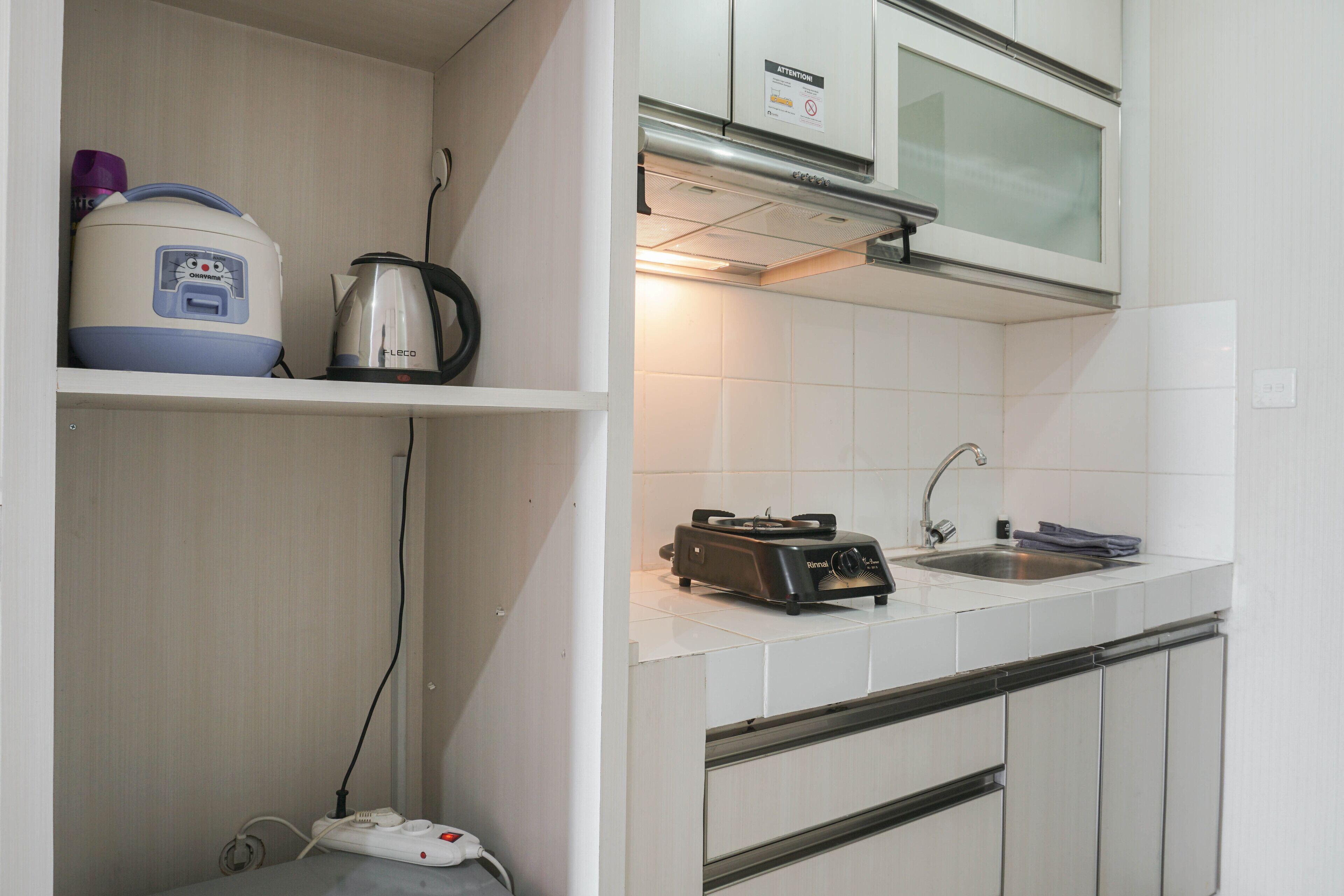 A kitchen with white cabinets, a toaster, a kettle, and a microwave.
