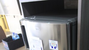 A stainless steel refrigerator in a kitchen with a countertop and a black storage box. - Nice And Fancy Studio Room At Menteng Park Apartment (Jakarta)