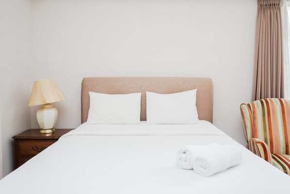 Relax in a cozy space with a comfortable bed, a nightstand, and a seating area.