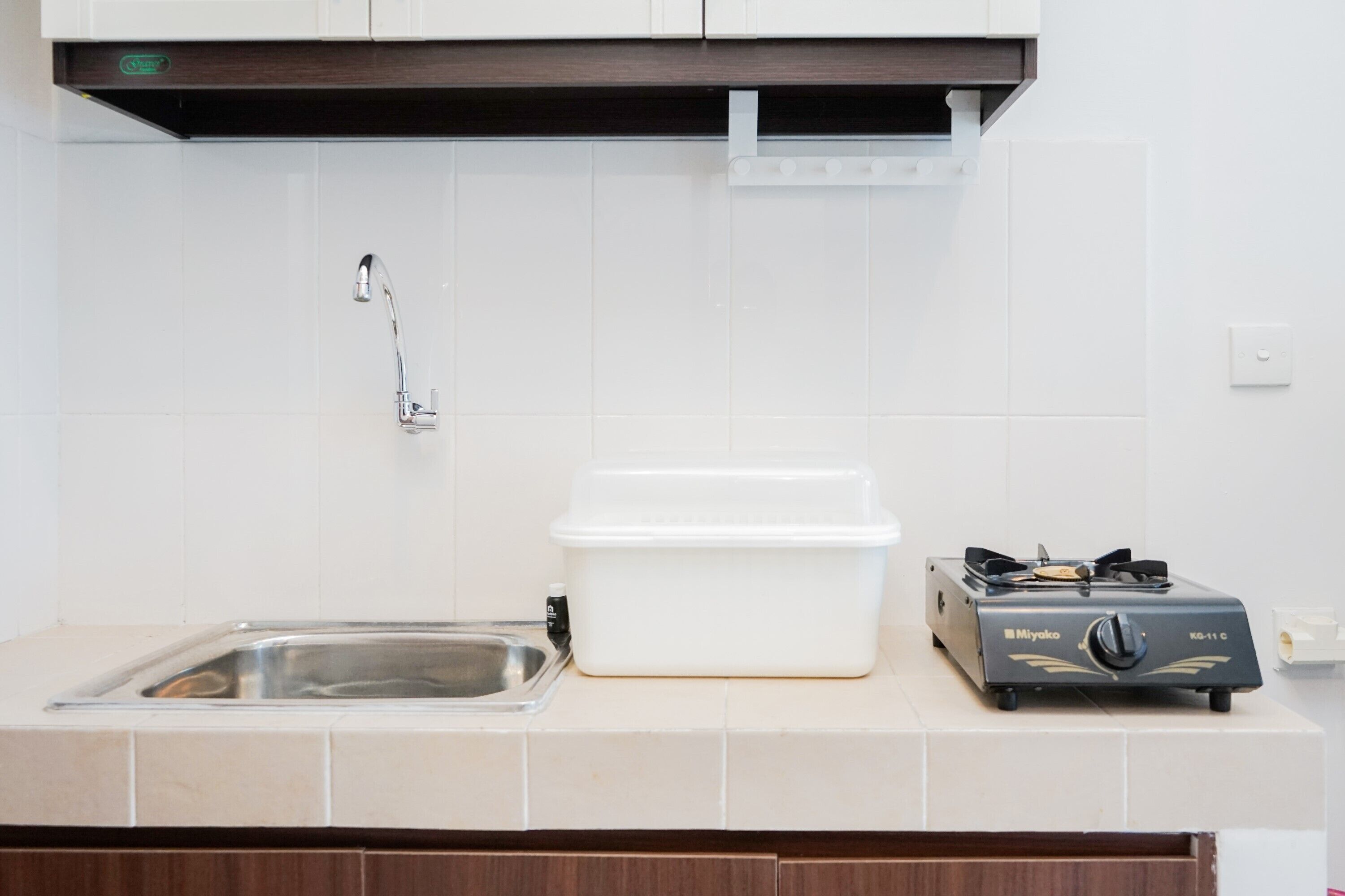 A kitchen with a sink, a white storage container, and a gas stove.