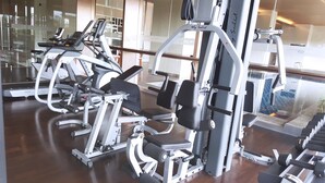 A gym with various exercise equipment, including treadmills, weight machines, and dumbbells.