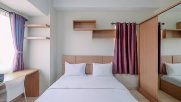 Una habitación de hotel con una cama, un escritorio y un armario.