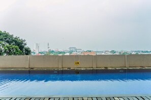 Ein Schwimmbecken mit Blick auf eine Stadtlandschaft im Hintergrund.