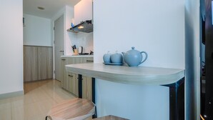 Een moderne keuken met een houten aanrecht, twee krukken en een spoelbak.