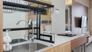 A modern kitchen with a double sink, a built-in dishwasher, and a countertop with a soap dispenser. - Best And Relax Studio Room Parkland Avenue Apartment (South Tangerang)