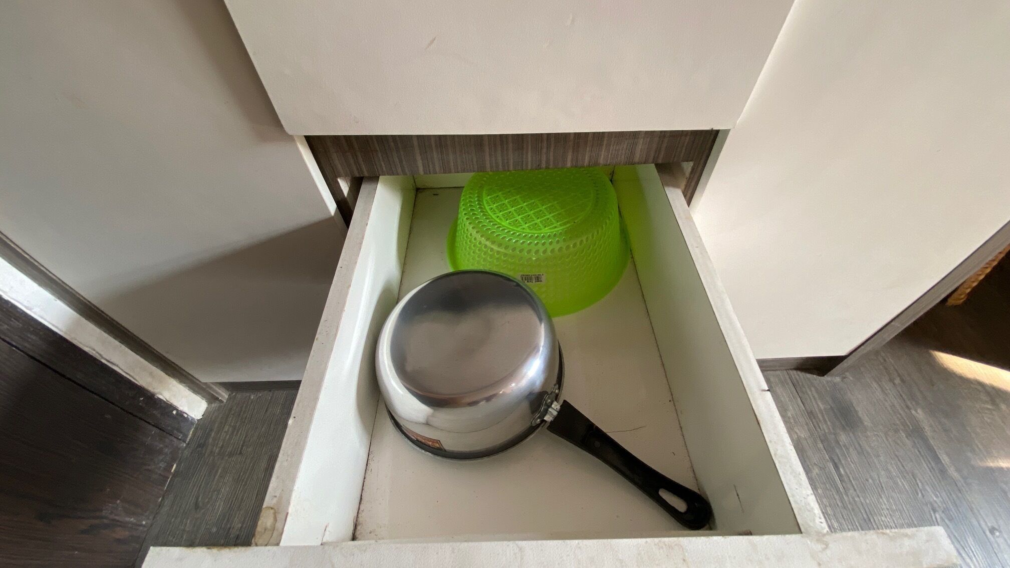 Een keukublade met een pan en een groene zeef.