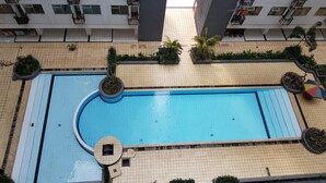 A rooftop swimming pool surrounded by greenery and modern buildings. - Cozy & Pleasant 2Br Apartment At The Jarrdin Cihampelas (Bandung)