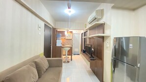 A compact living space with a kitchenette, a sofa, and a refrigerator. - Cozy & Pleasant 2Br Apartment At The Jarrdin Cihampelas (Bandung)
