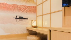 A room with a traditional Japanese-style wall mural, a woven basket, and a wall-mounted TV. - Japanese Cozy Style Studio At Bintaro Embarcadero Apartment (South Tangerang)