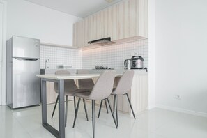 Une cuisine moderne équipée d’un réfrigérateur en acier inoxydable, d’une cuisinière à gaz et d’une machine à café.