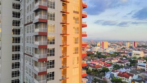 A high-rise building with multiple balconies and a view of a cityscape. - Luxurious 2Br At Vida View Makassar Apartment (Makassar)