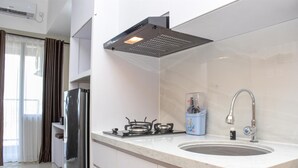Uma cozinha moderna com fogão a gás, geladeira de aço inoxidável e pia com torneira.