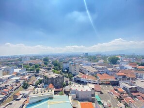 A cityscape with a mix of modern and older buildings, a prominent church spire, and a clear sky. - Gorgeous & Classic 2Br At Braga City Walk Apartment (Bandung)