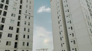Un immeuble résidentiel de grande hauteur, doté de nombreux étages, de balcons et surplombant un ciel dégagé.