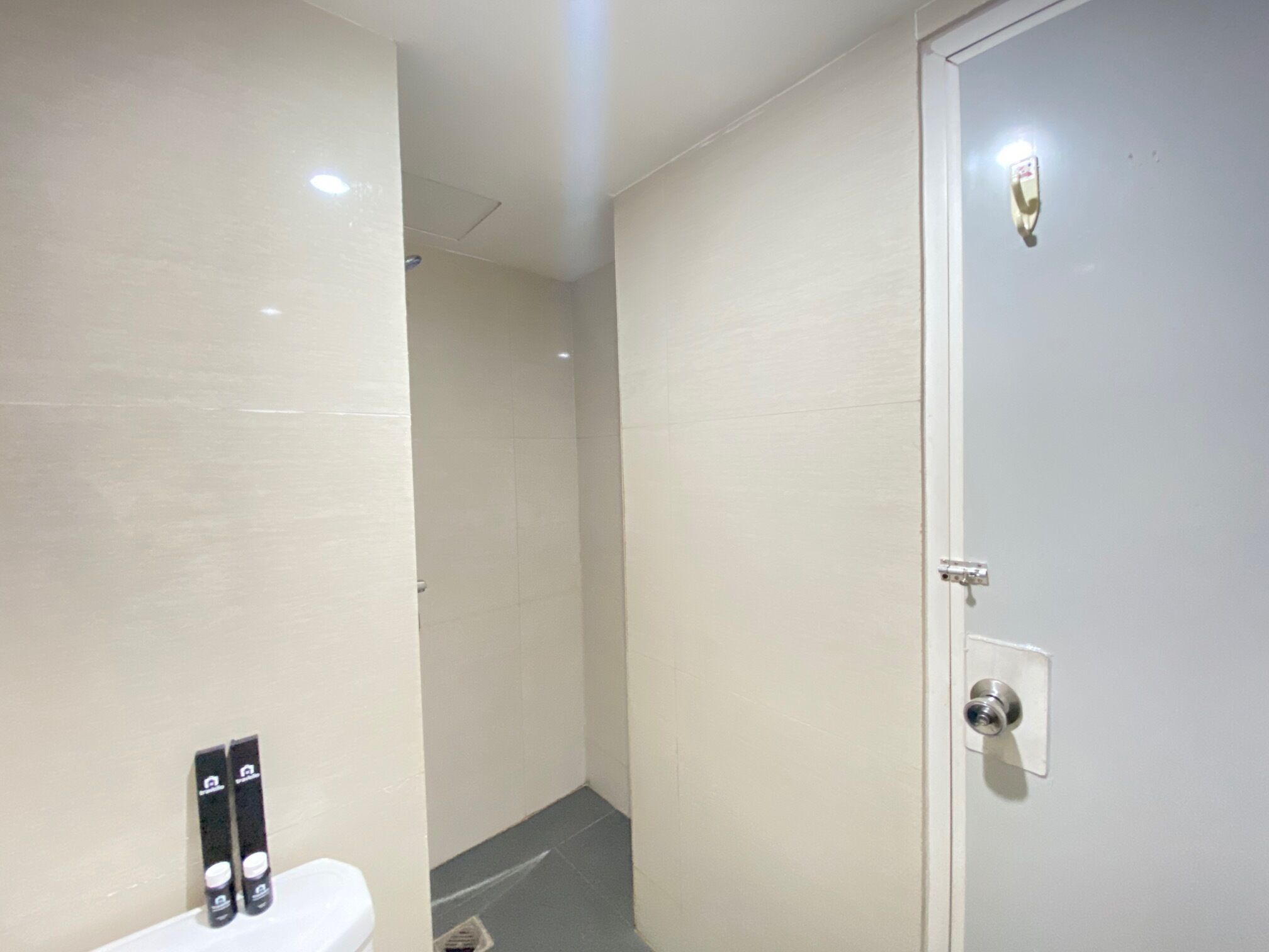 A bathroom with a toilet, a shower stall, and a door with a lock.