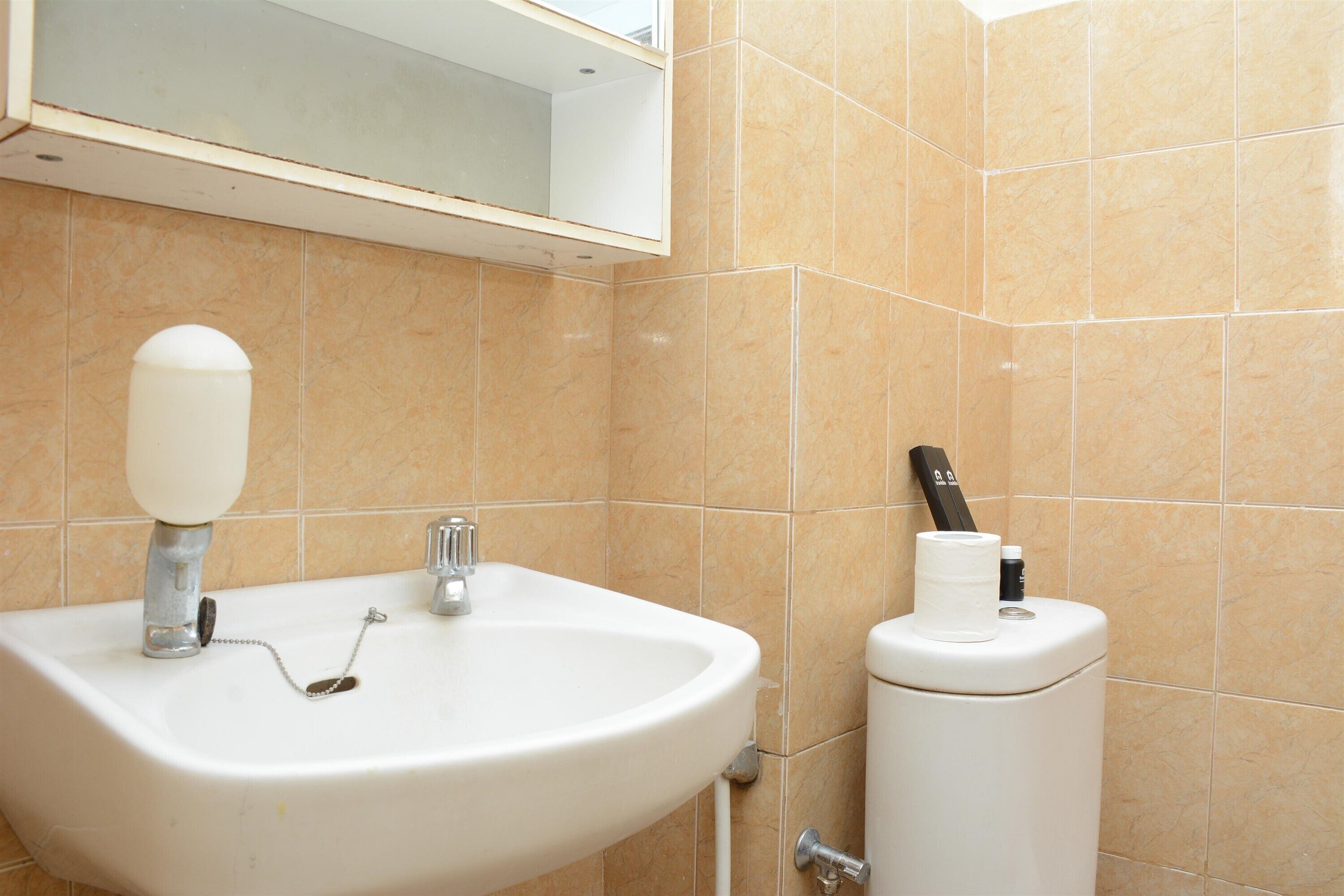 A bathroom with a white sink, a mirror, and a toilet.