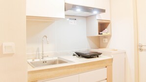 A compact kitchen with a sink, a stove, and a countertop. - Great Choice 2Br Apartment At Meikarta (Cikarang)