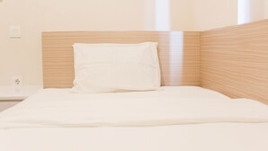 A neatly made bed with a wooden headboard, a white pillow, and a white mattress cover. - Great Choice 2Br Apartment At Meikarta (Cikarang)