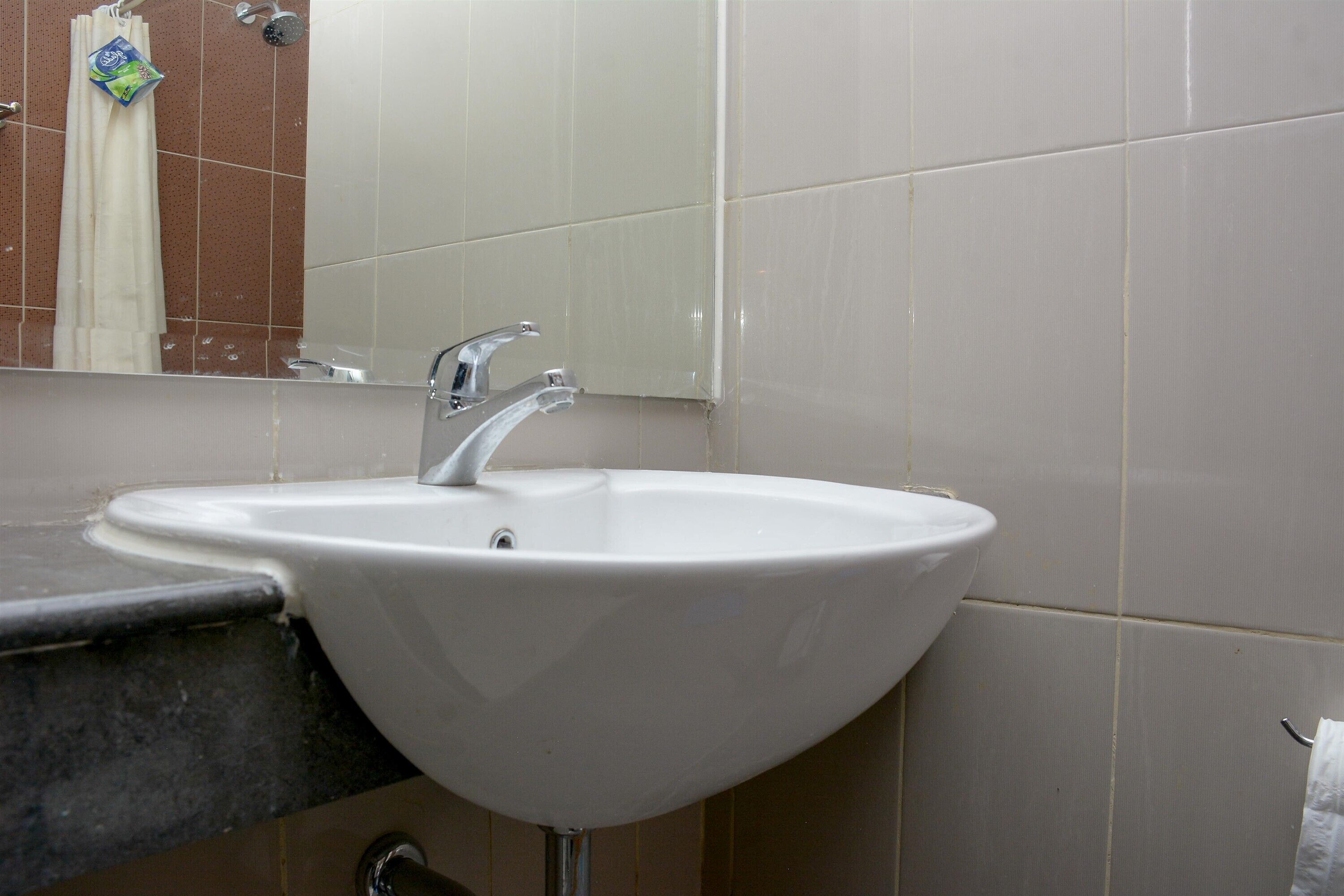 A bathroom with a white sink, a mirror, and a shower.