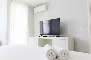 Relax in a stylish room with a flat-screen TV, comfortable bed, and clean lines.