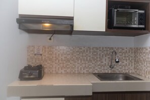 Room | Private kitchen | Fridge, stovetop, electric kettle, cookware/dishes/utensils - Homey And Comfort Studio At The Enviro Apartment (Cikarang)