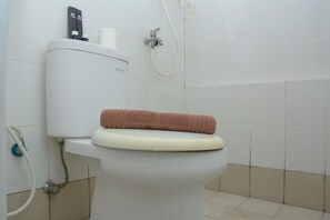 Bathroom features a shower, toilet, and towel storage.