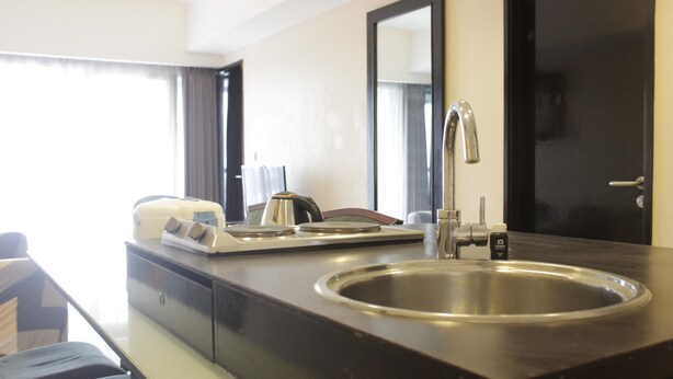 A modern bathroom with a large sink, a mirror, and a coffee maker.