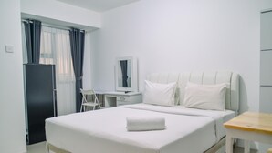 A hotel room with a bed, a desk, a chair, a mirror, and a wardrobe.
