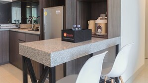 Eine moderne Küche mit Granit-Arbeitsplatte, einem Kühlschrank, einer Kaffeemaschine und einer mit 'travelio' beschrifteten Schachtel.
