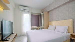 Une chambre d’hôtel moderne équipée d’un grand lit, d’une télévision à écran plat, d’un bureau et d’un miroir.