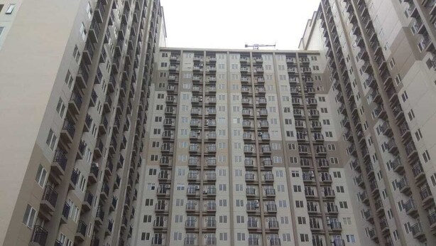Un immeuble résidentiel de grande hauteur, doté de nombreux balcons et d’une façade uniforme.