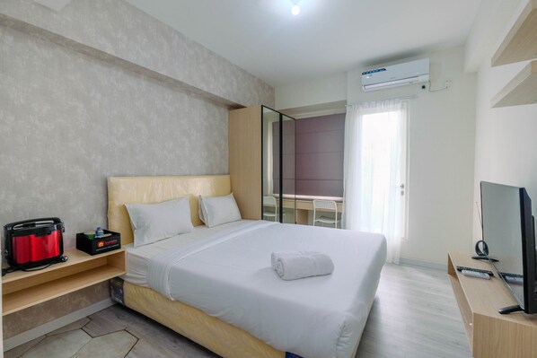 Relax in a spacious room with a large bed, flat-screen TV, and air conditioning for a comfortable stay.