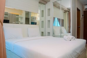 A hotel room with a large bed, a mirror, and a view of the outside. - Cozy With Good Location Studio At Tifolia Apartment By Travelio (Jakarta)