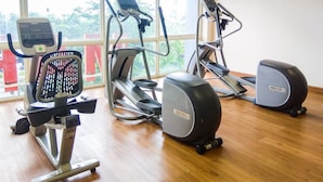 A gym with cardio machines, a rowing machine, and a stationary bike. - Cozy And Simply Studio Tifolia Apartment Near Kelapa Gading By Travelio (Jakarta)