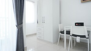 A room with a white wardrobe, a desk, and a chair. - Relax Studio Apartment At The Nest Near Puri By Travelio (Tangerang)