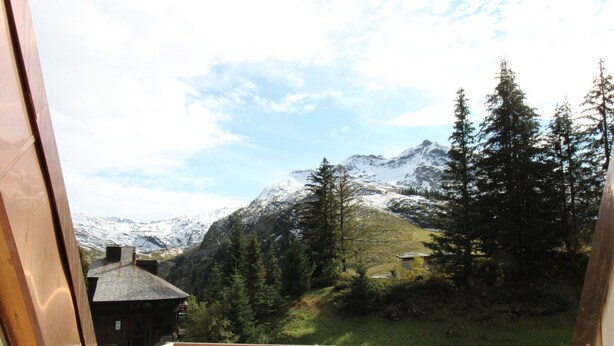 A balcony with a view of snow-capped mountains, a forest, and a building in the background. - Renovated triplex apt for 7 in Avoriaz, terrace, ski locker (Avoriaz)