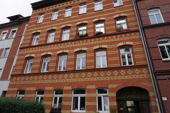 A multi-story red brick building with arched windows and a patterned facade.