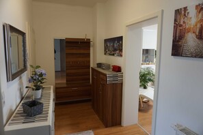 A hallway with a wooden cabinet, a radiator, and a potted plant.