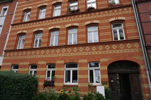 A red brick building with multiple windows and a door. - Poldi 3 - Apartments Poldi (Erfurt)
