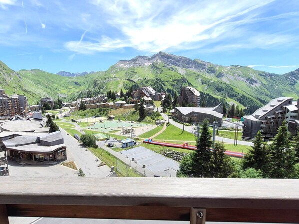 A mountainous town with buildings, a ski lift, and a road.