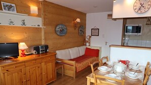 A cozy wooden interior with a sofa, dining table, and kitchen area. - Avoriaz: Renovated apartment for 5 guests with WIFI (Avoriaz)