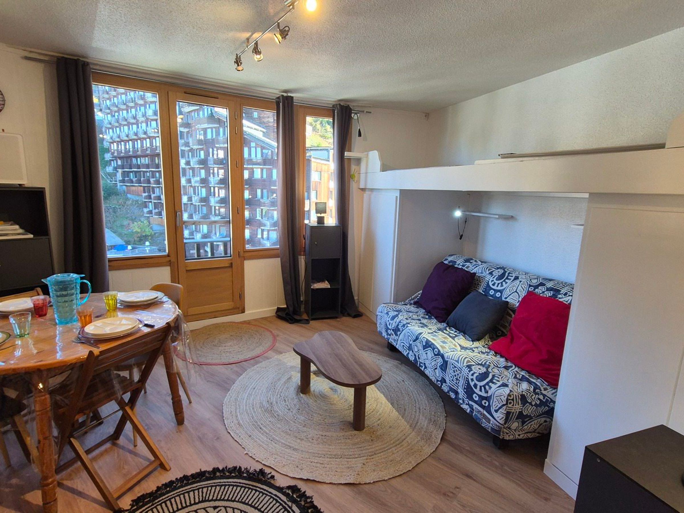 Un espace de vie compact comprenant un coin repas, un canapé et une petite table.